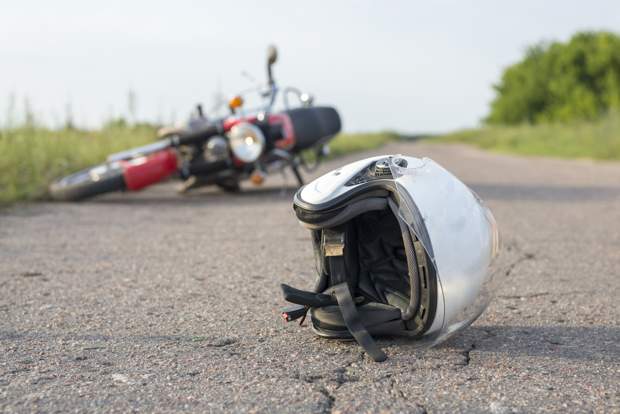 Photo of helmet and motorcycle on road, the concept of road accidents